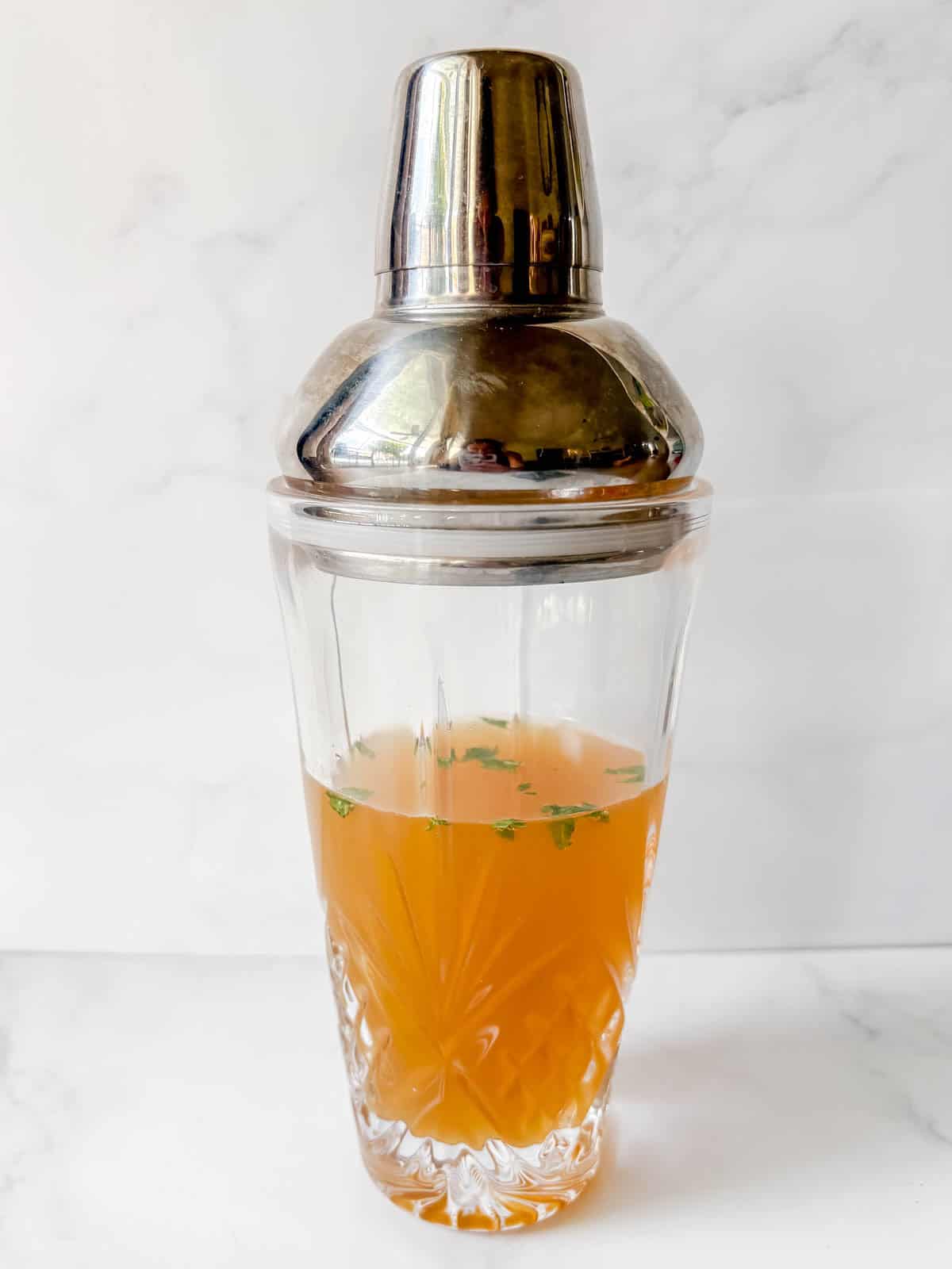 All the ingredients needed to make a passion fruit cocktail in a cocktail shaker.
