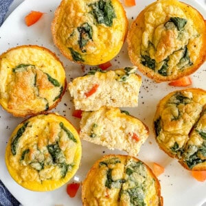 High protein egg bites in a plate. The middle egg bite is cut in half and you can see the smooth texture of it.