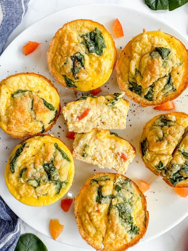 High protein egg bites in a plate. The middle egg bite is cut in half and you can see the smooth texture of it.