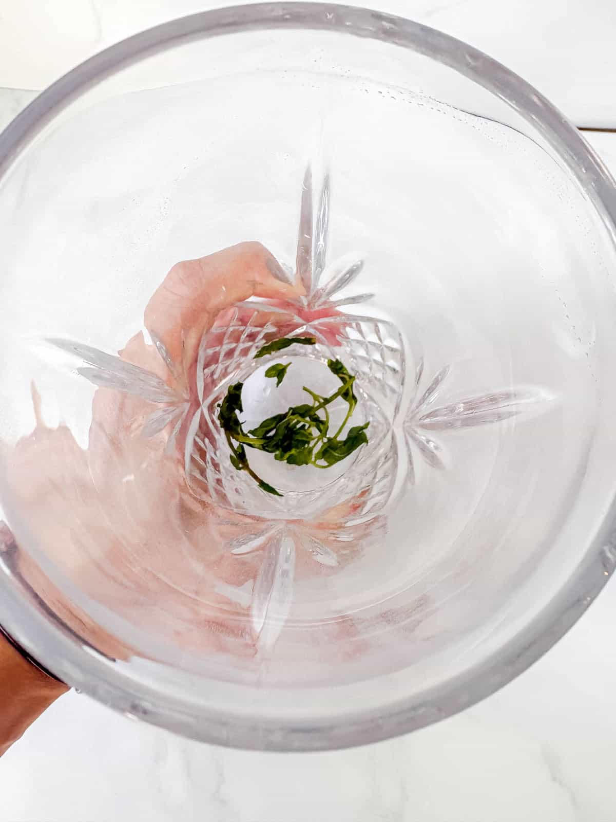 Muddling the mint leaves in a drink shaker.