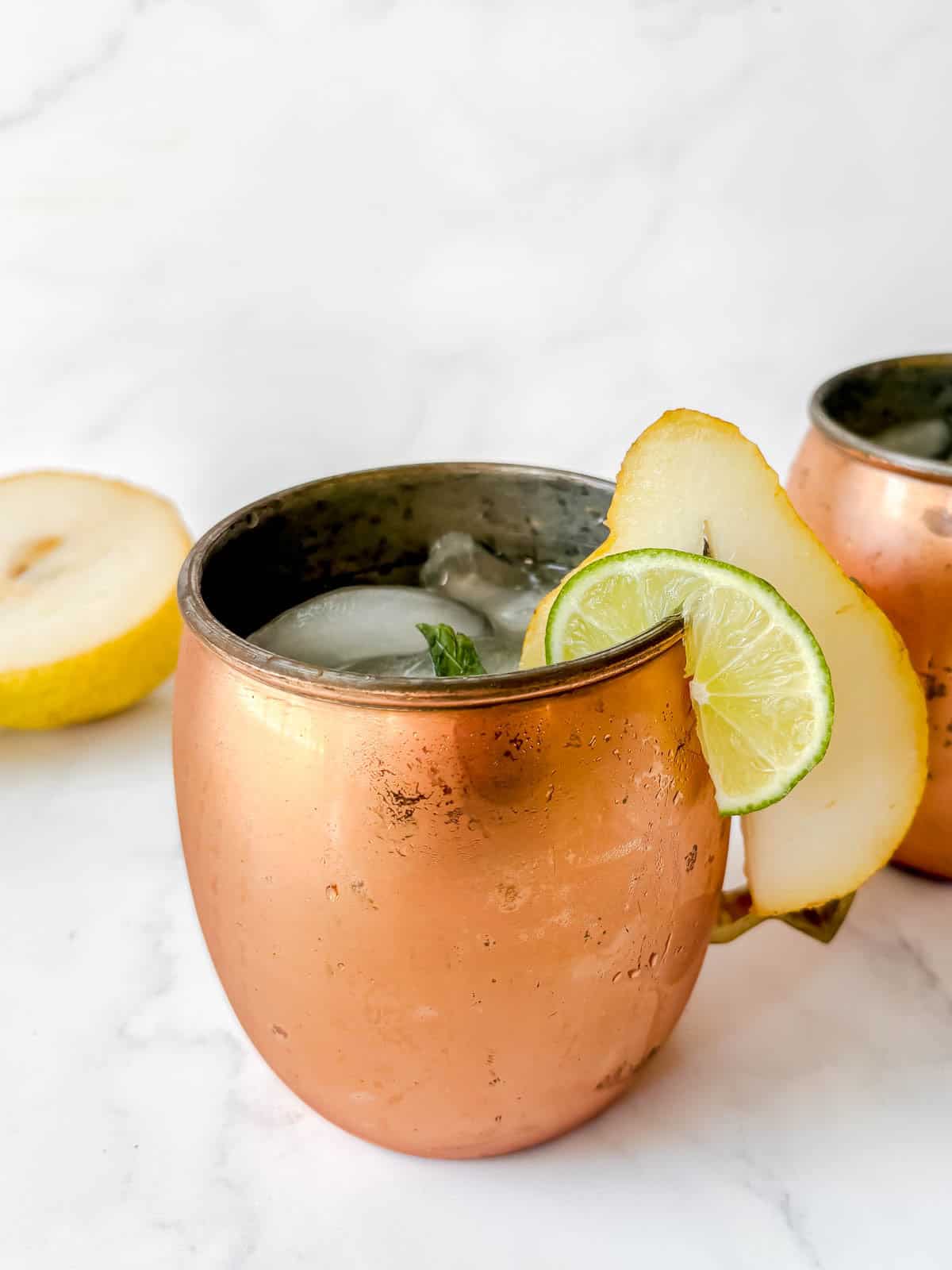 Pear cocktail poured into a cup filled with ice.