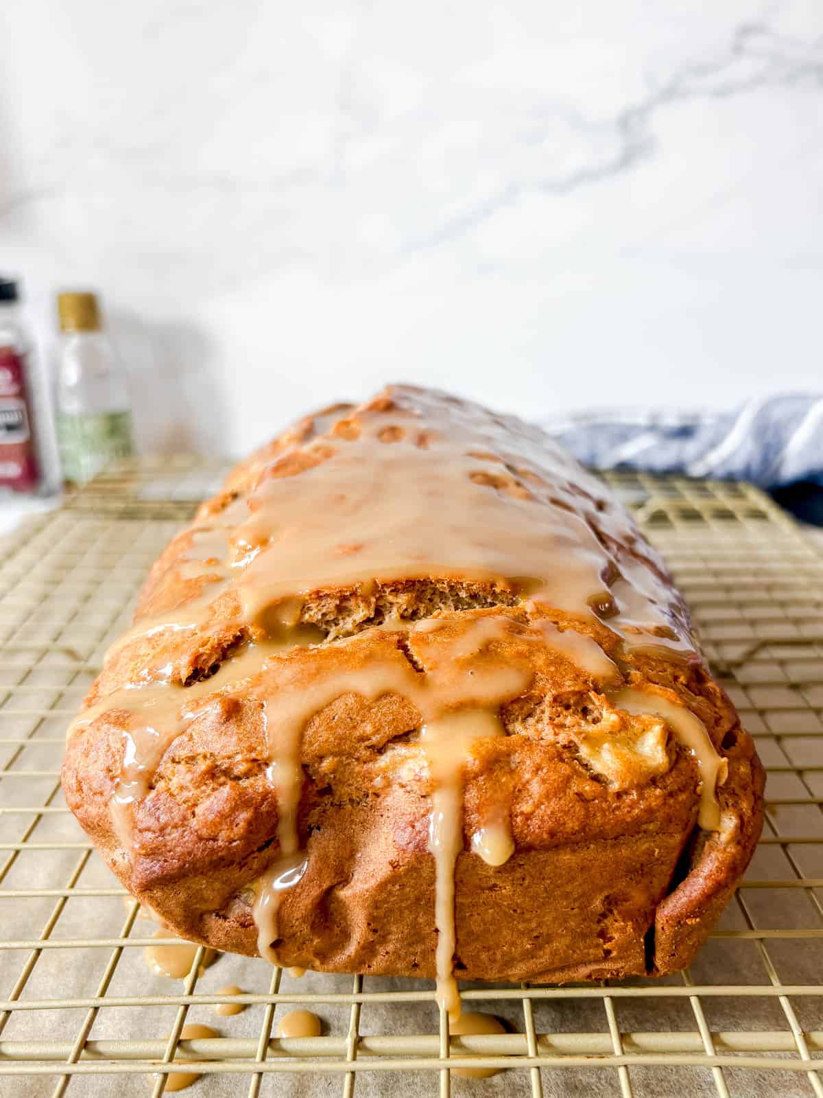 Maple banana bread covered in maple glaze on a drying rack.