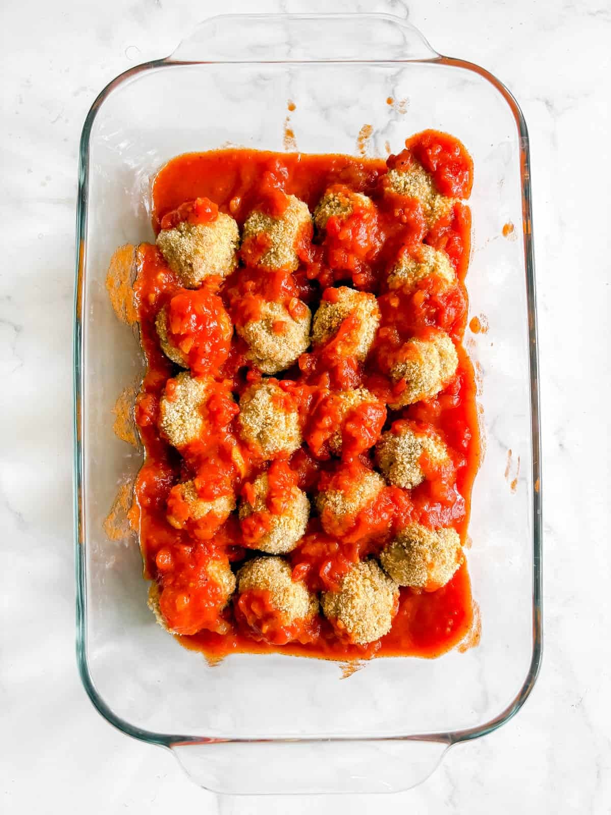 Chicken parmesan meatballs covered in marinara sauce.