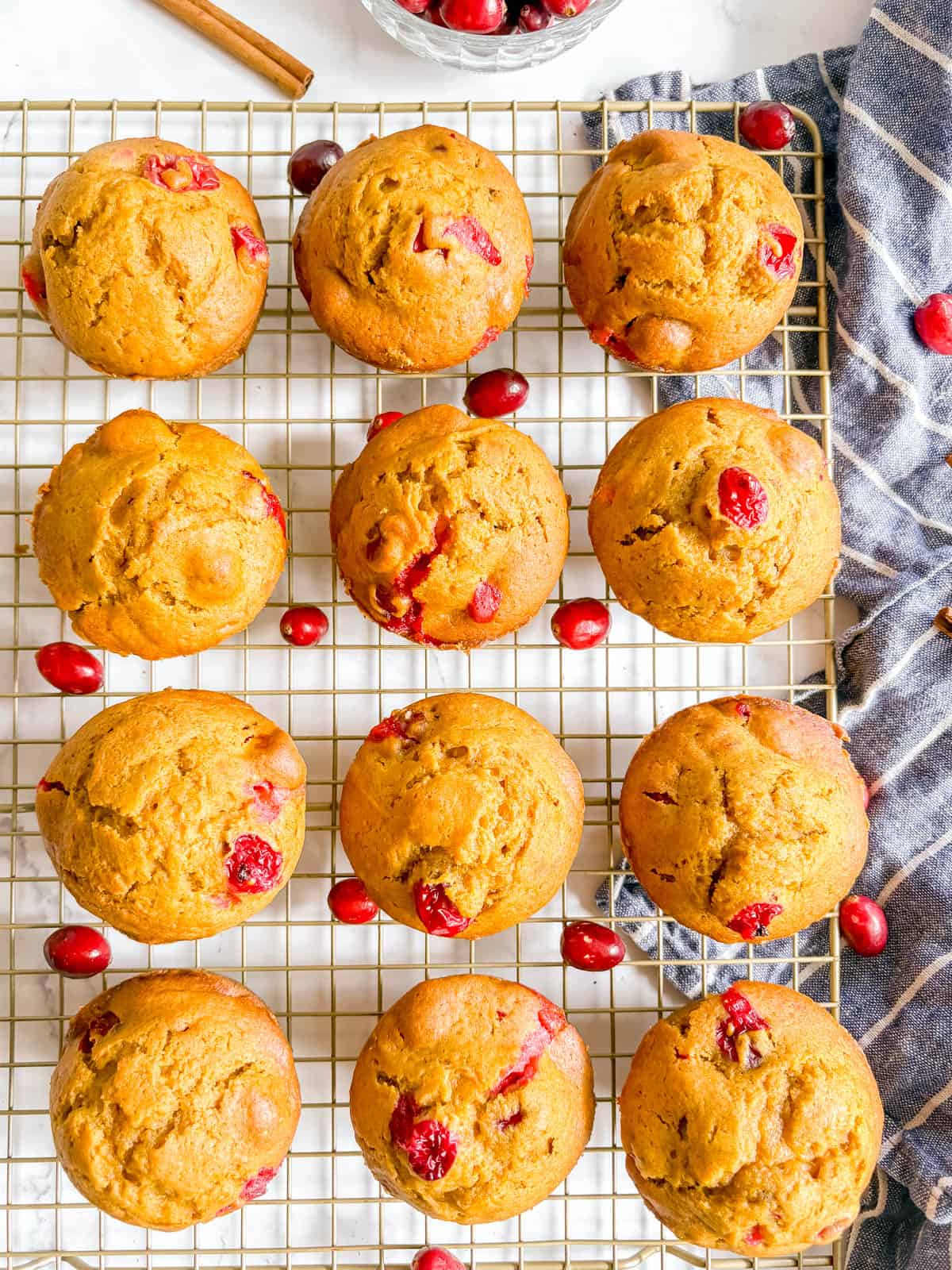 Pumpkin cranberry muffins cooling on a wire rack.